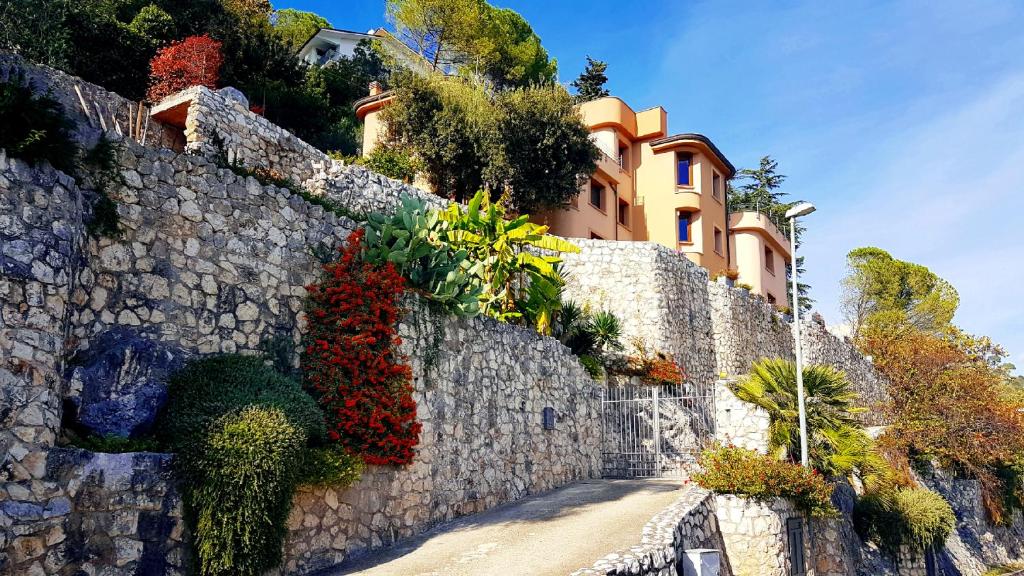a building on a stone wall with plants on it at La Residenza di Carolina in Cassino