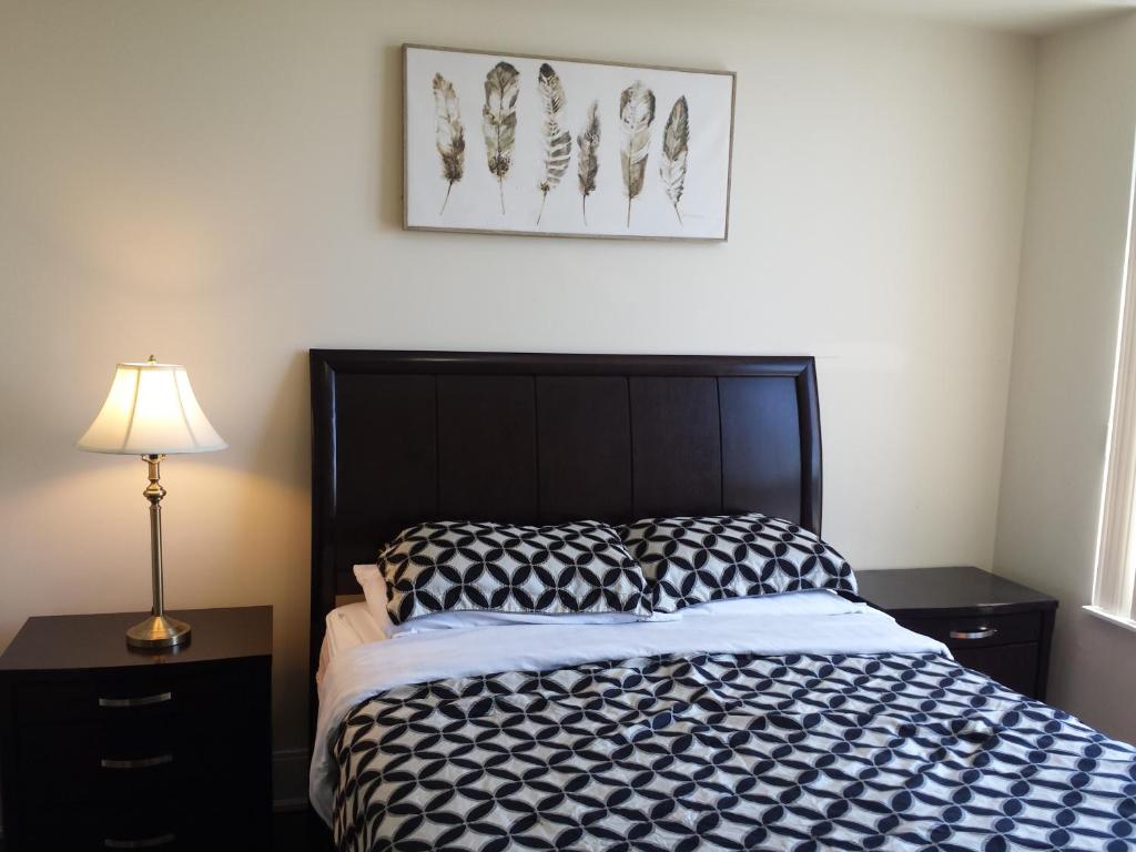 a bedroom with a black and white bed and a lamp at 2 BEDROOM 2 Bathroom Best Value Prime Location in Missisauga in Mississauga