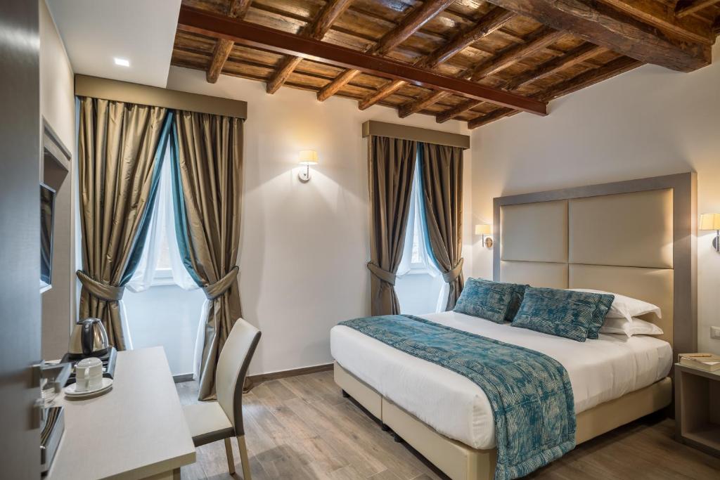 
a hotel room with a bed and a dresser at Reginella Suites in Rome
