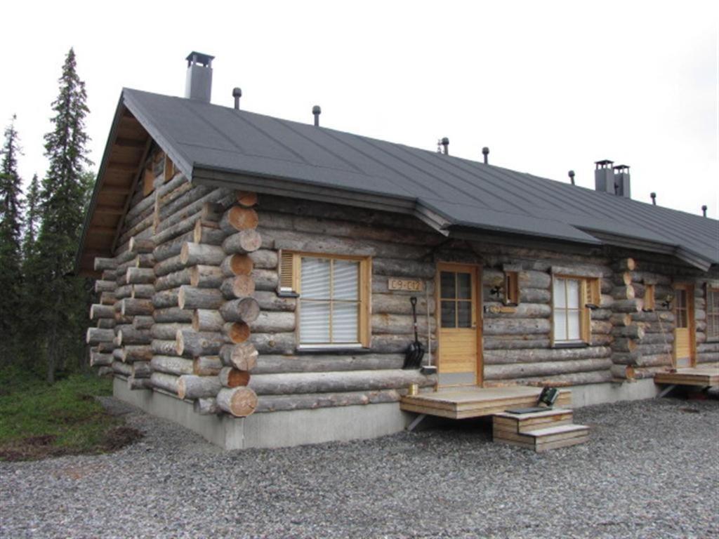 Cabaña de madera con porche y puerta en Lost Inn Cabins, en Äkäslompolo