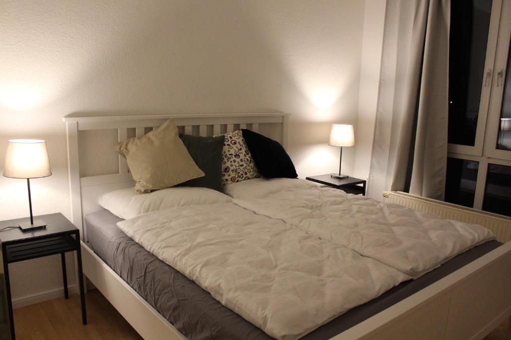 コルシェンブロイヒにあるBusiness Apartment near Neuss/Düsseldorfの大きな白いベッド(テーブルにランプ2つ付)