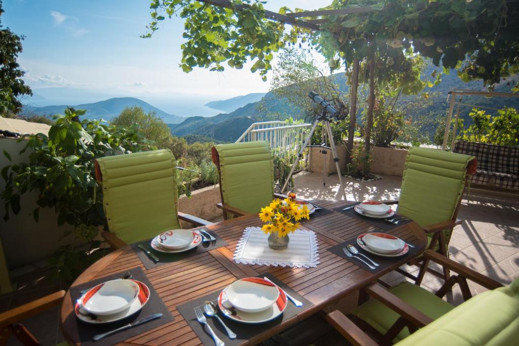 einen Holztisch und Stühle auf einem Balkon mit Aussicht in der Unterkunft Cottage Hill in Áyios Ilías