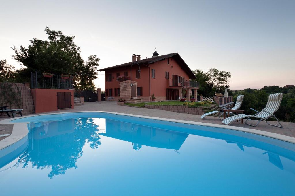 a swimming pool in front of a house at B&B Castelvecchio in Ferrere