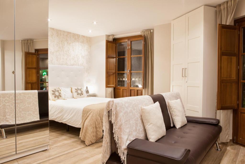 2 fotos de un dormitorio con cama y sofá en Apartamentos Boutique Salamanca, en Salamanca