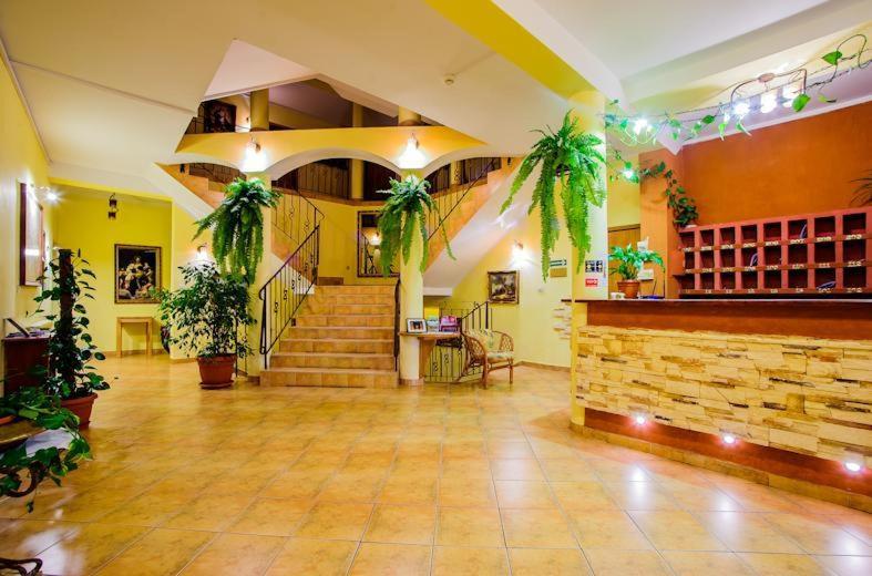a large room with stairs and potted plants at Hotel Jan in Szczawnica