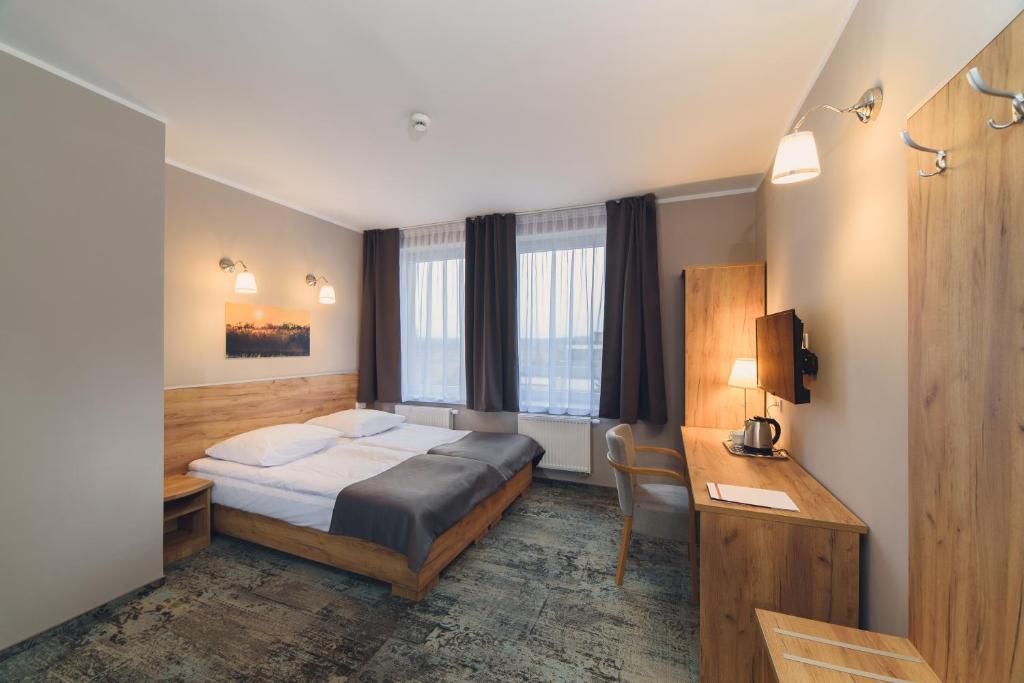 ein Hotelzimmer mit einem Bett und einem Schreibtisch in der Unterkunft Hotel Pod Jesiotrem in Łabiszyn