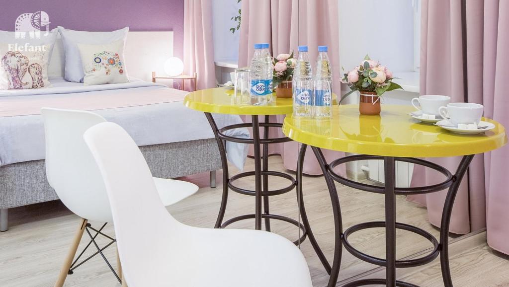 a room with a yellow table and two white chairs at Elefant in Saint Petersburg