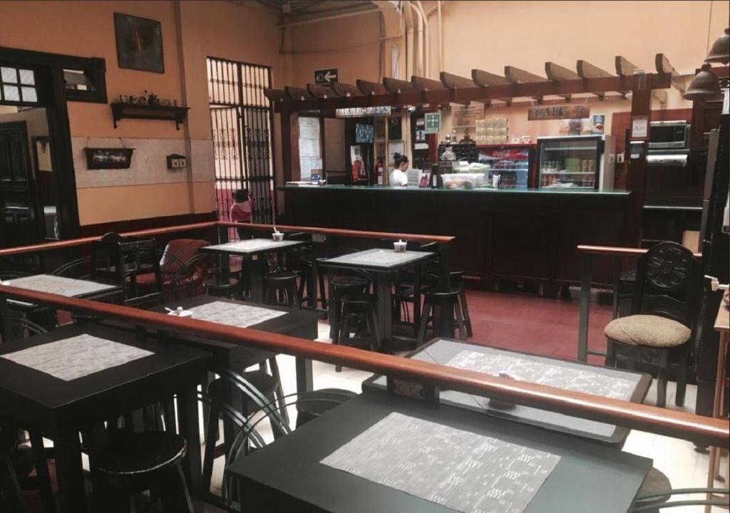 un restaurante con mesas y sillas y un bar en Hotel Ajau en Guatemala