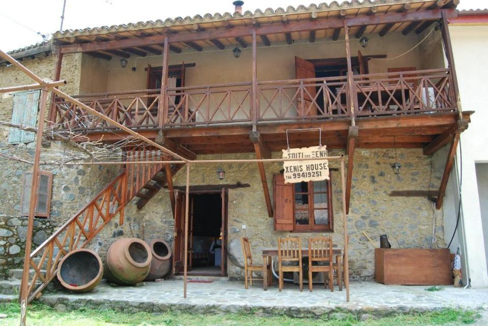 a building with a balcony and a table and chairs at Xenis House in Galata