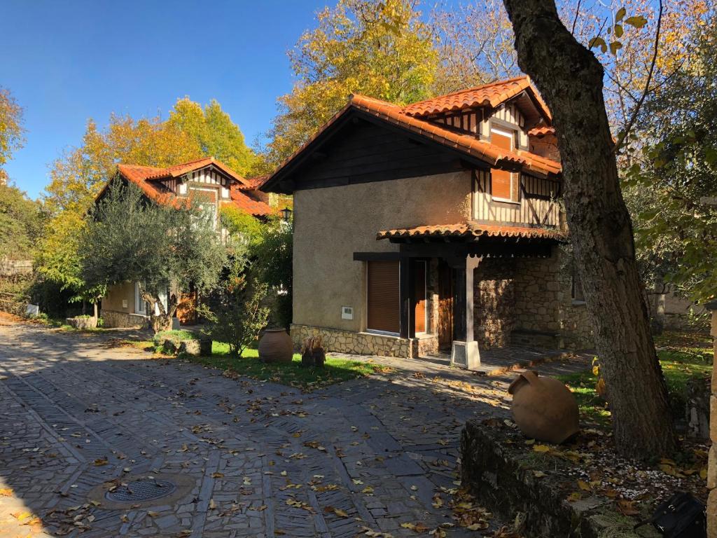 a house with a tree next to a street at Casitas Del Huerto in La Alberca