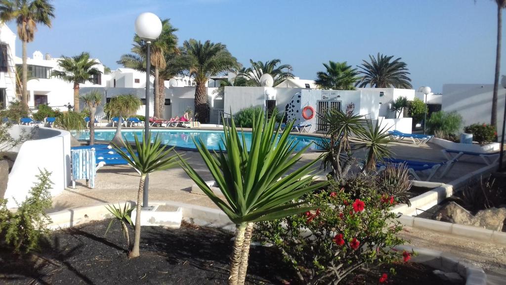 un resort con piscina e palme di Bastian Nauplius a Costa Teguise