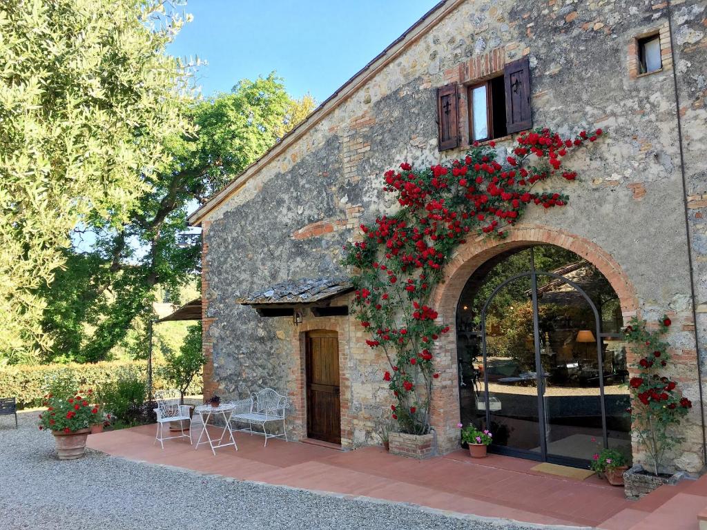 budynek z czerwonymi kwiatami w obiekcie B&B Countryhouse Villa Baciolo w mieście San Gimignano