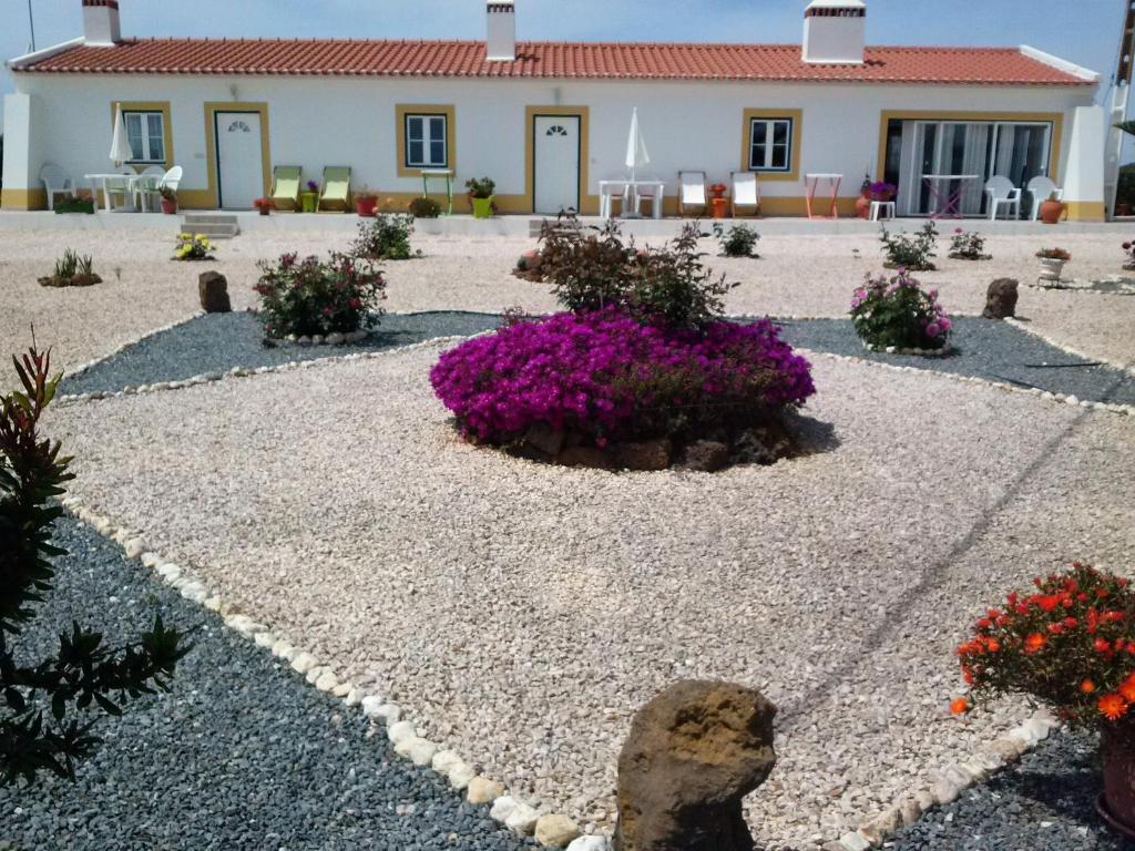 un jardín con flores púrpuras frente a un edificio en Casa Nova da Barreira en Cavaleiro