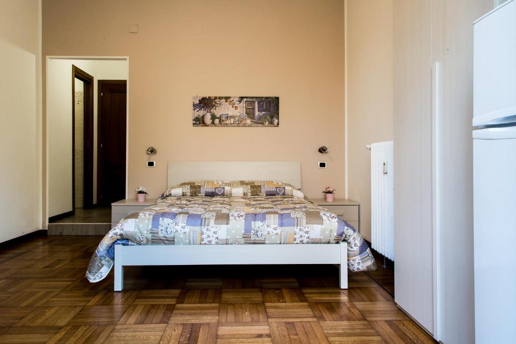 een slaapkamer met een bed en een houten vloer bij B&B Zara in Milaan
