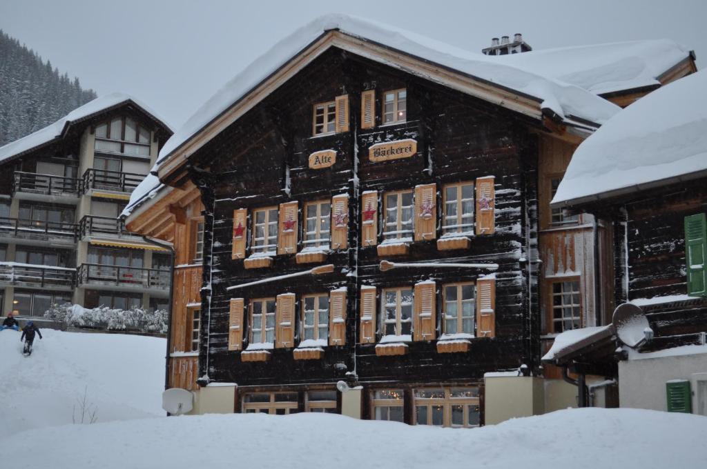 ミューレンにあるFerienwohnung Alte Bäckereiの雪の木造建築