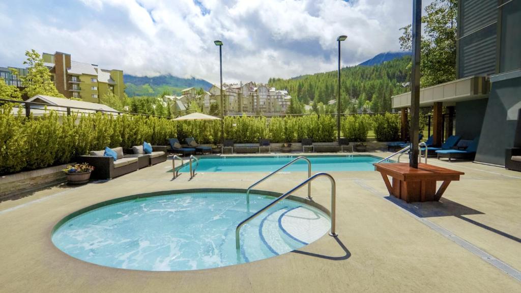 a swimming pool with a hot tub on a building at Aava Whistler Hotel in Whistler