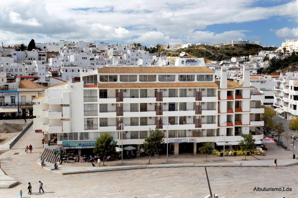 Edificio Albufeira Apartamentos A. Local - Albuturismo Lda في ألبوفيرا: مبنى ابيض كبير امام مدينة