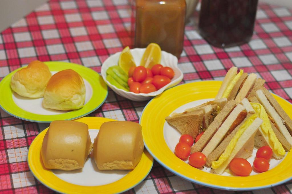 a table with plates of food with sandwiches and fruit at Happy Orange Homestay in Dongshan