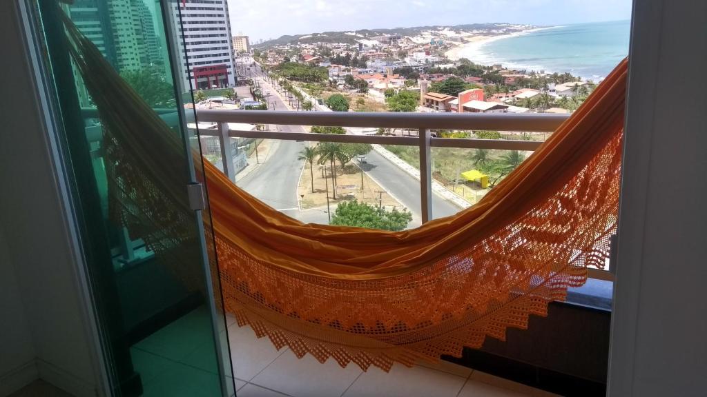 a hammock on a balcony with a view of the beach at Dunna Barcane in Natal