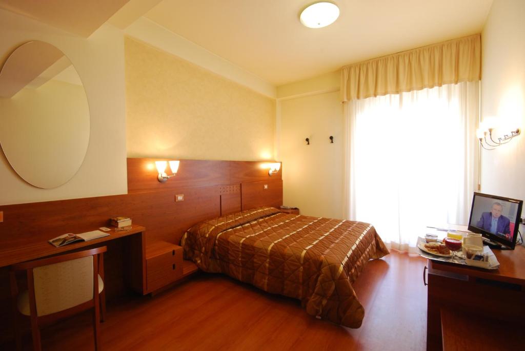 a hotel room with a bed and a large window at Hotel Gala in Pesaro