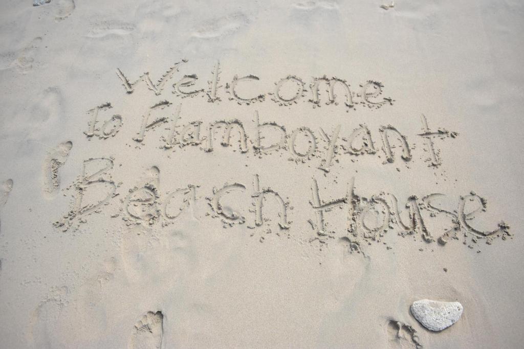 a message written in the sand on the beach at Flamboyant Beach House in Saint James