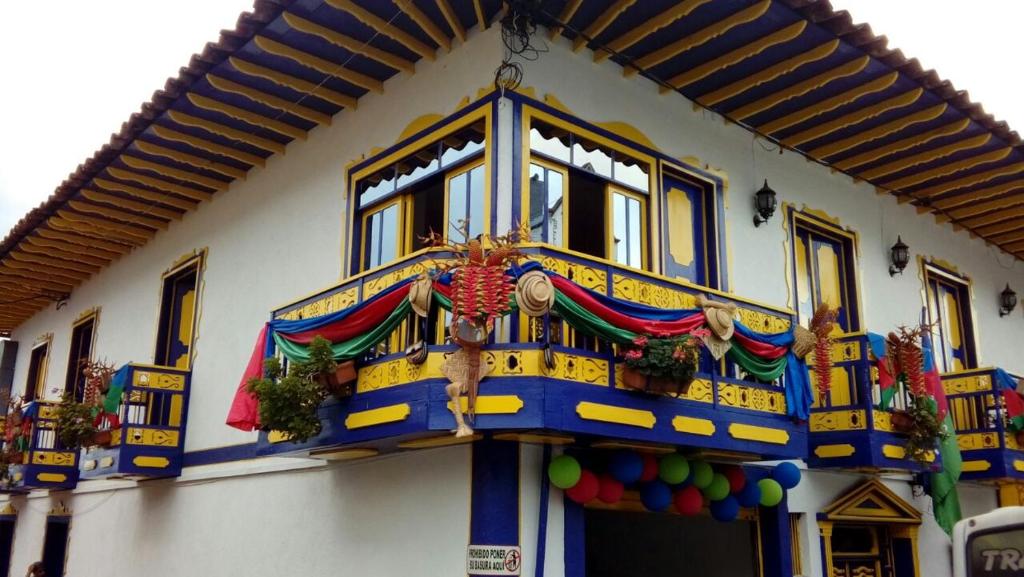 a building with a colorful facade with a window at Hotel Junior Plaza in Apía