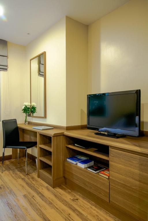 a room with a desk with a television and a chair at Sima Thani Hotel in Nakhon Ratchasima