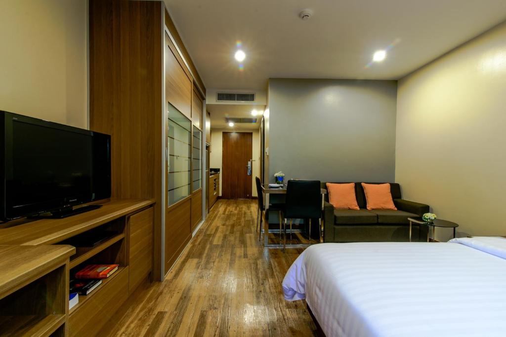 a hotel room with a bed and a flat screen tv at Sima Thani Hotel in Nakhon Ratchasima