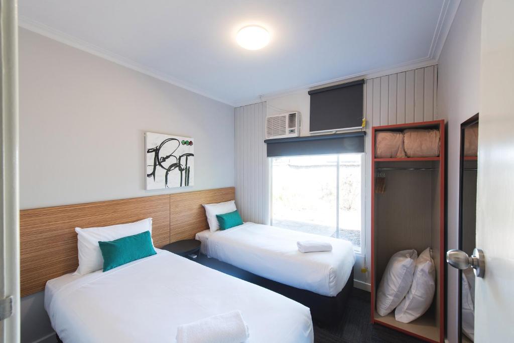 
a hotel room with two beds and two lamps at Links Hotel in Adelaide

