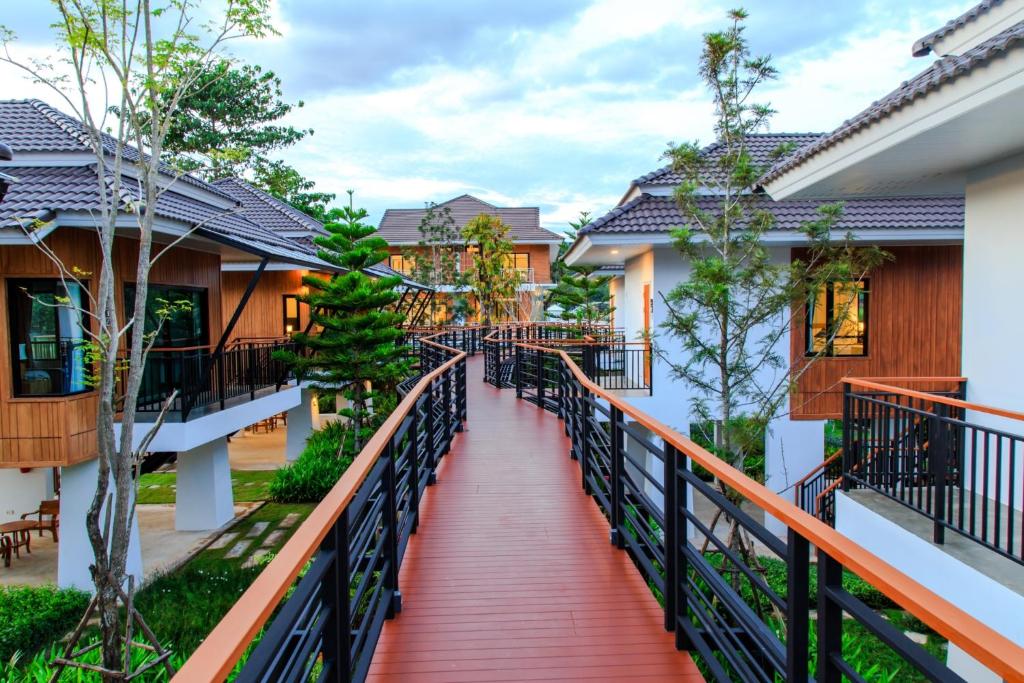 a red walkway leading to a house with trees at Phuruakeeree Resort in Loei