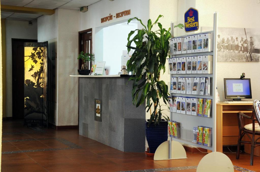 a waiting room with a desk and a plant at Best Western Hotel Dom Bernardo in Faro