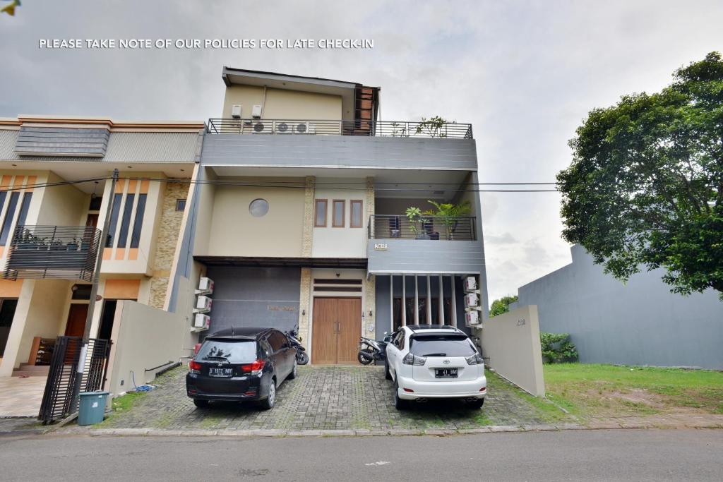 dom z dwoma samochodami zaparkowanymi przed nim w obiekcie Casa Vanda Guesthouse w mieście Serpong