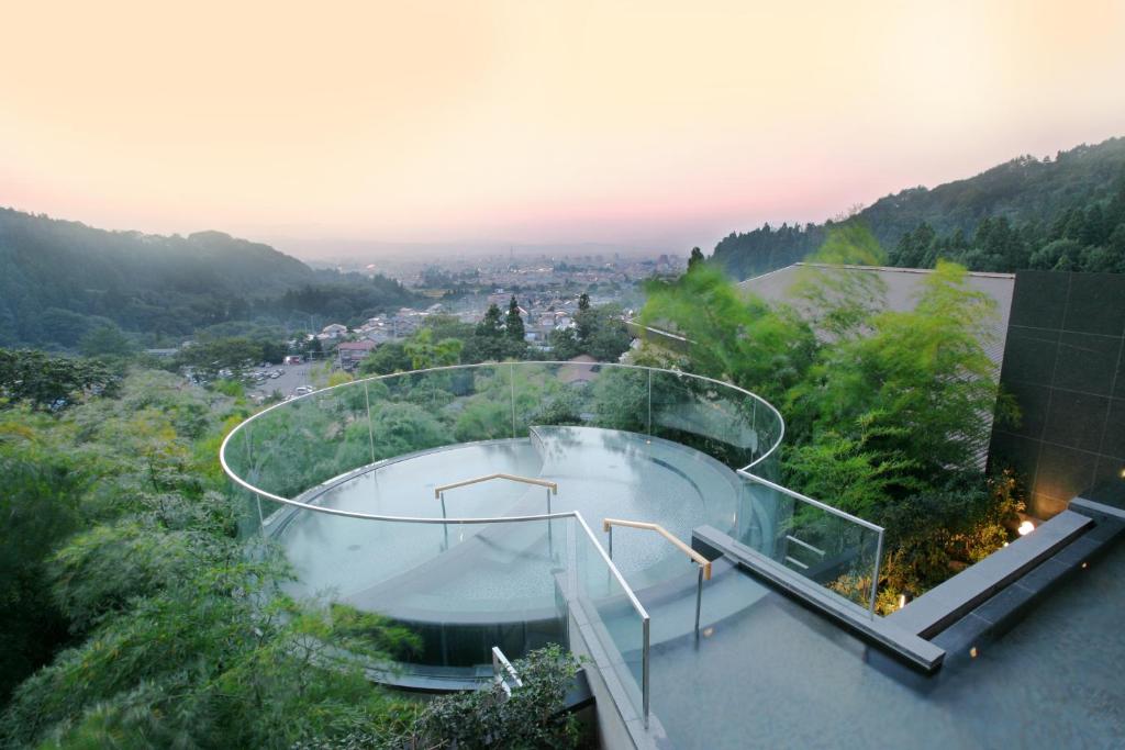 a house with a swimming pool on top of a hill at Onyado Toho in Aizuwakamatsu