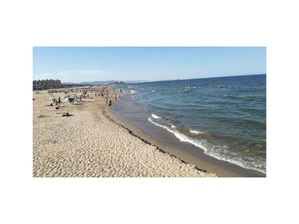 un grupo de personas en una playa cerca del agua en Piso en Malvarrosa, en Valencia