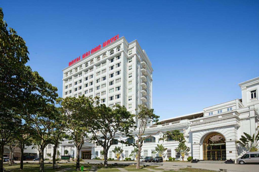 a large white building with a red sign on it at Royal Halong Hotel in Ha Long