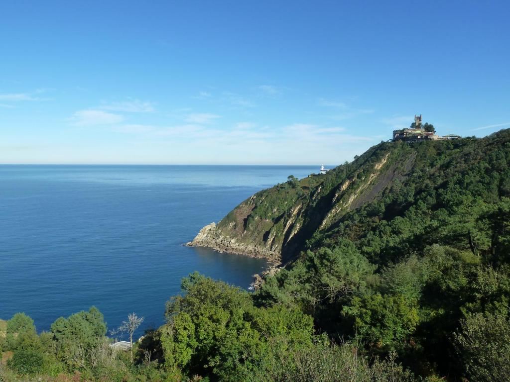 ein Haus auf einem Hügel neben dem Meer in der Unterkunft Hotel Leku Eder in San Sebastián