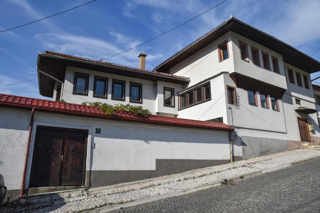 una casa blanca con techo rojo en una calle en Ismar Residence, en Sarajevo