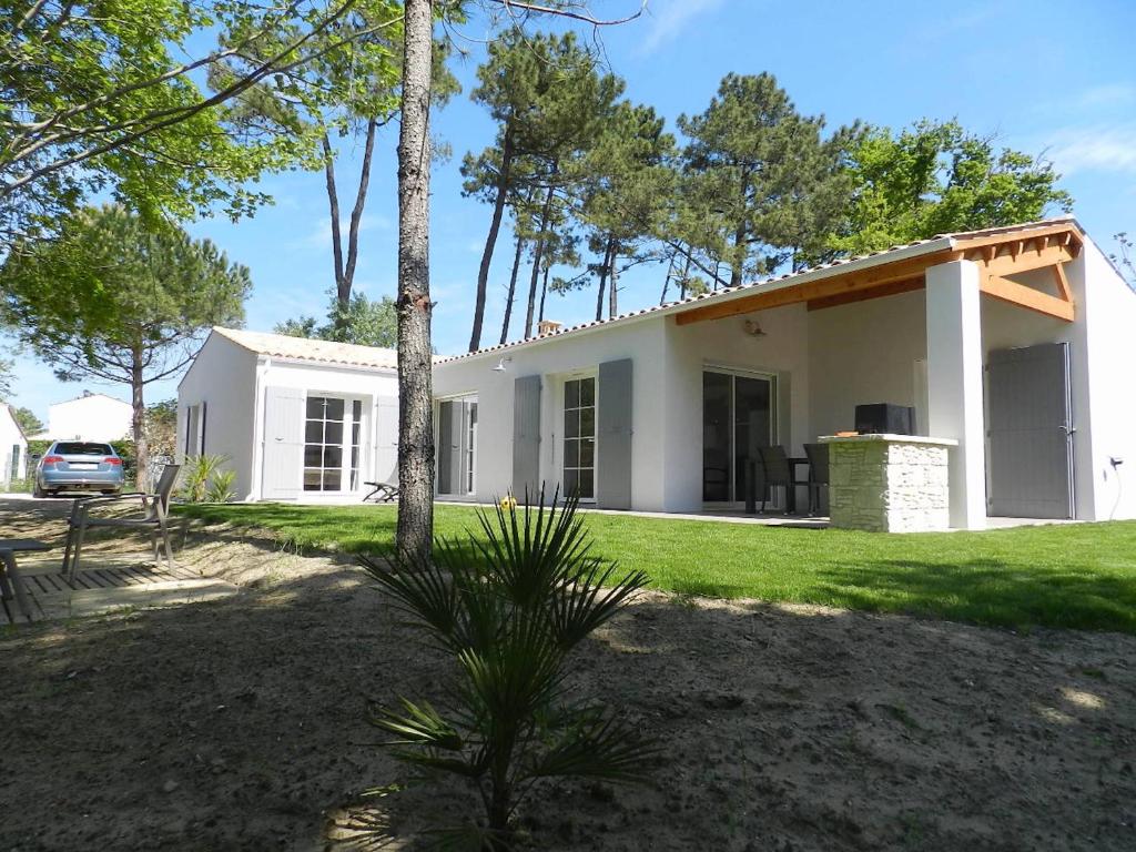 ein weißes Haus mit einem Baum davor in der Unterkunft Parad'iles in Dolus d'Oléron
