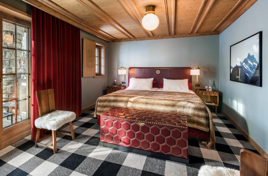 a bedroom with a large bed and a chair at Apogée Courchevel, Oetker Hotels in Courchevel