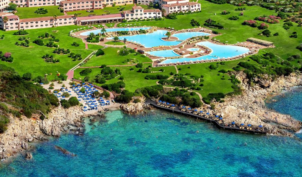 Luftblick auf ein Resort mit blauem Wasser in der Unterkunft COLONNA RESORT, a Colonna Luxury Beach Hotel, Porto Cervo in Porto Cervo