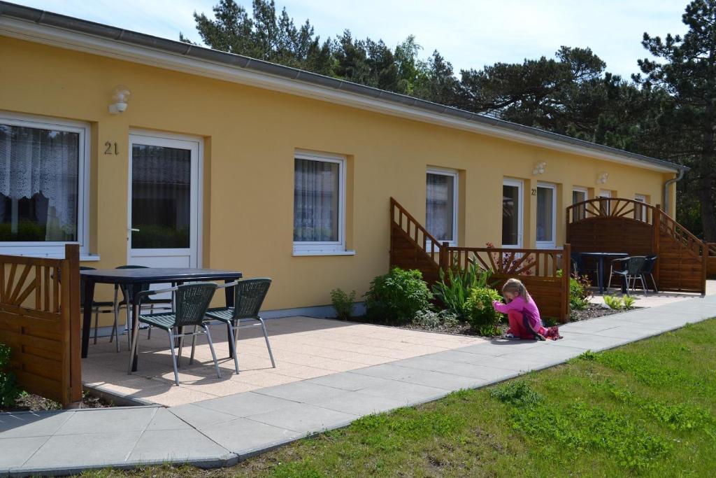 Une petite fille assise sur un trottoir devant une maison dans l'établissement Camp Am Wasser, à Juliusruh