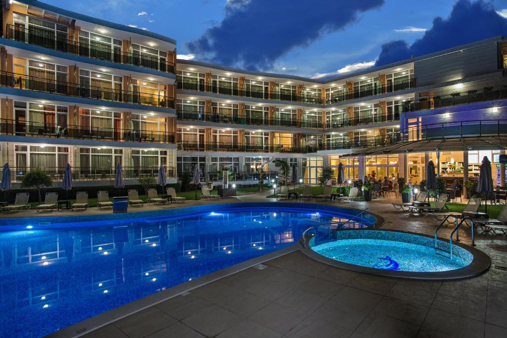 un hotel con piscina frente a un edificio en Hotel Miramar Sozopol en Sozopol