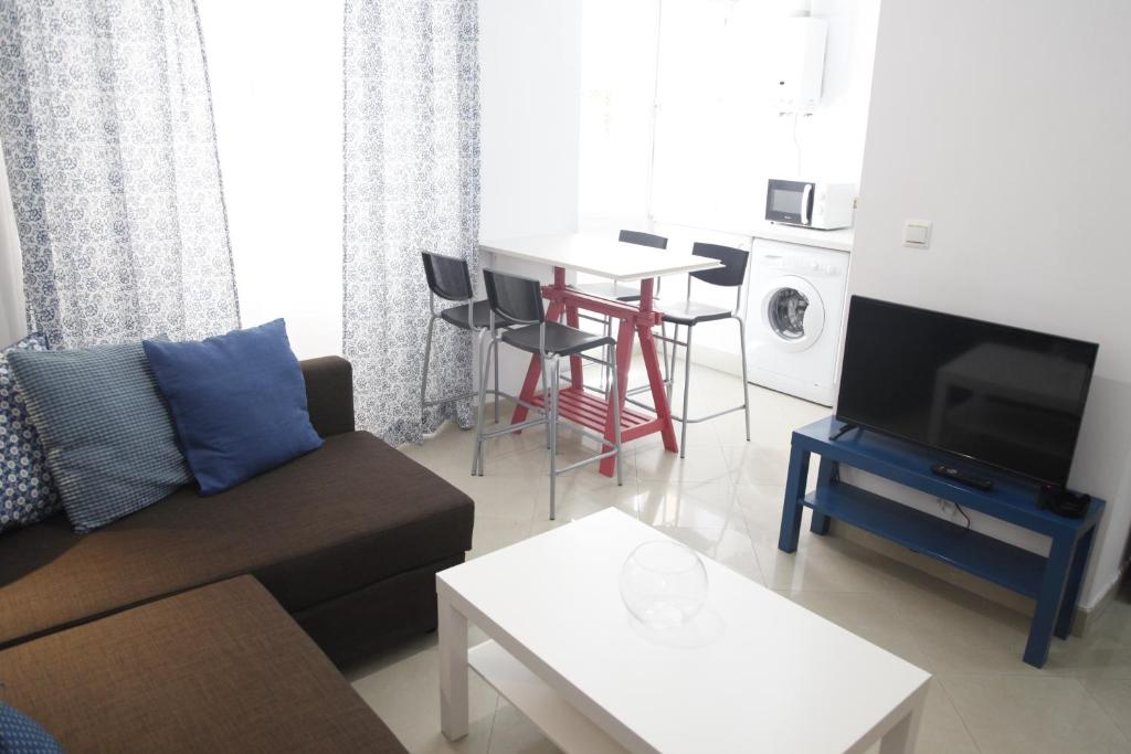 salon z kanapą i stołem w obiekcie FANTÁSTICO PISO, JUNTO AL TEATRO FALLA Y A LA PLAYA w Kadyksie