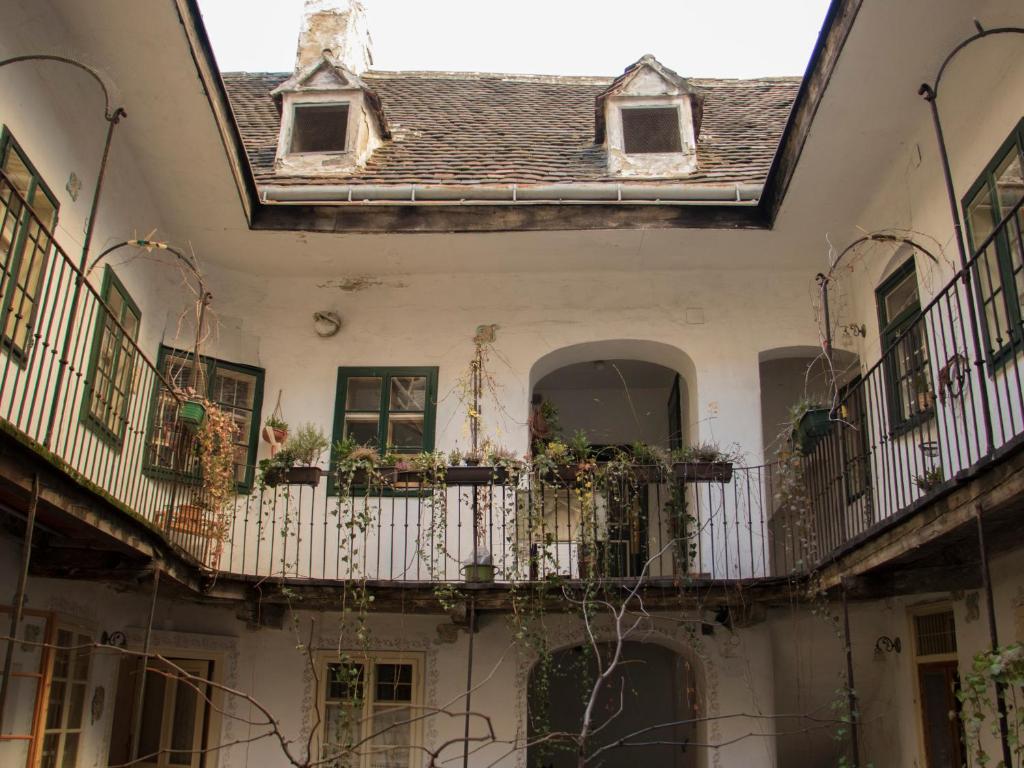 an old house with balconies and flowers on a balcony at VOLKSinn in Vienna