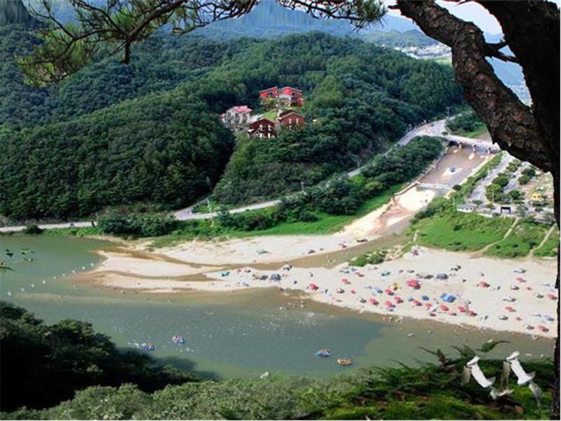 a beach with chairs and umbrellas in the water at Heidi Korea in Hongcheon