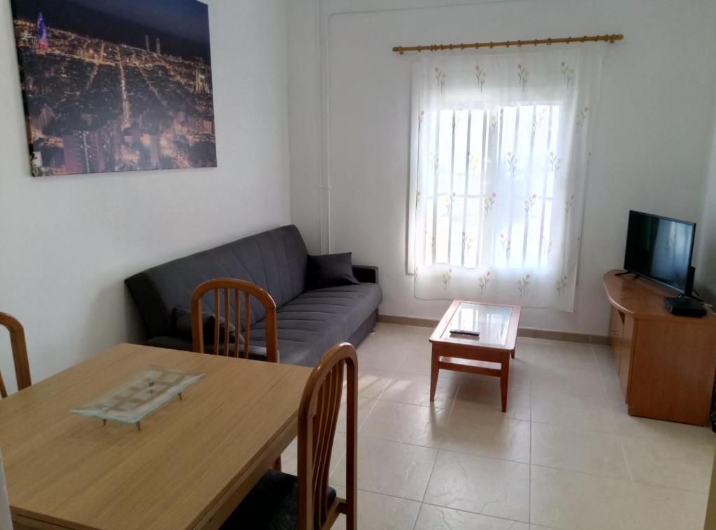 ein Wohnzimmer mit einem Sofa und einem Tisch in der Unterkunft Casa Carmen Barcelona in El Prat de Llobregat