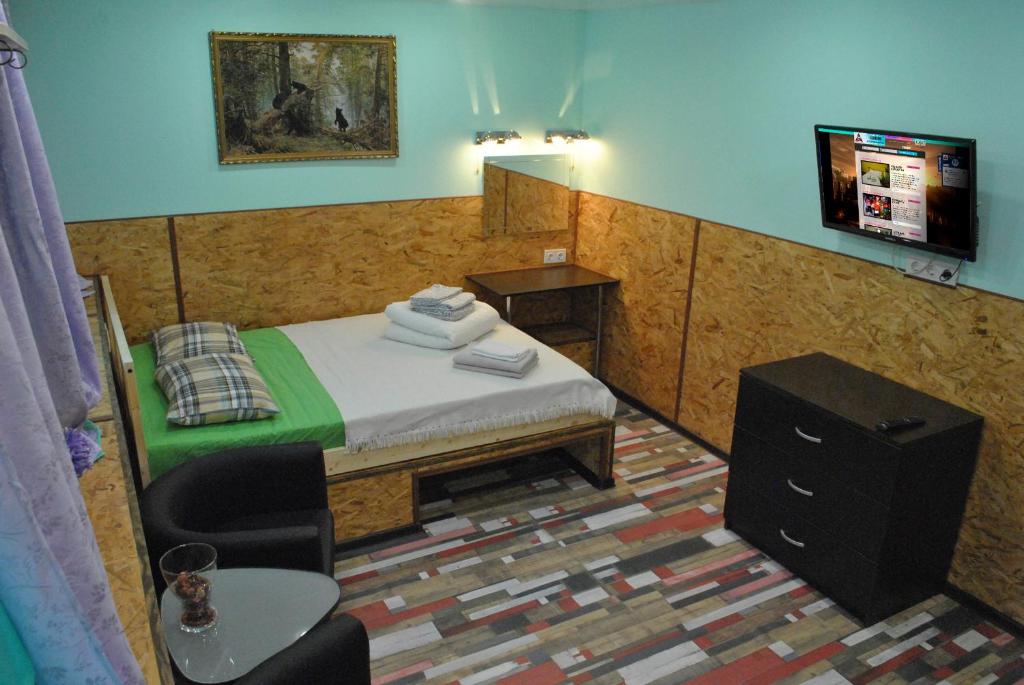a bedroom with a bed and a tv on a wall at Apartments Vavilon 4 in Yekaterinburg