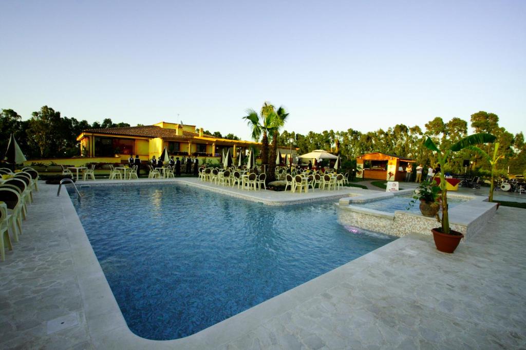 a swimming pool with tables and chairs in a resort at Su Soi in Càbras
