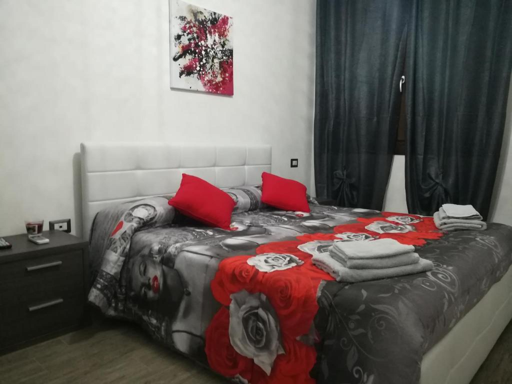 una camera da letto con un letto con cuscini rossi di Rooms Loru a Sestu