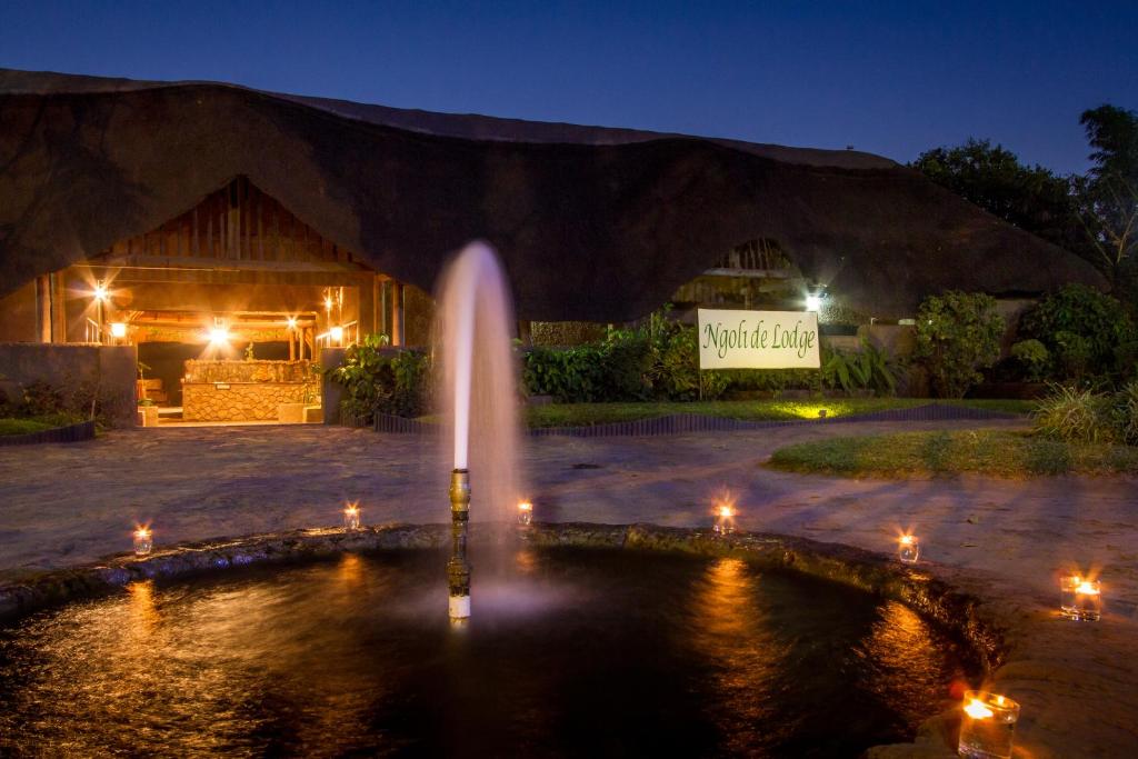 una fuente frente a un edificio por la noche en Ravine Lodge, en Livingstone